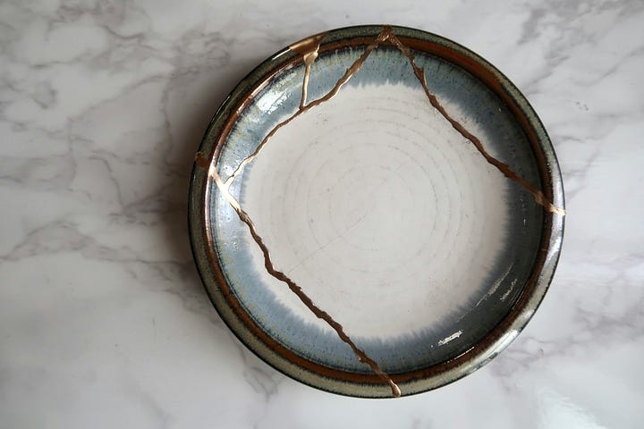 A gracefully shaped ceramic vase with delicate golden Kintsugi repairs running across its surface, illustrating the beauty and value found in accepting and celebrating flaws.A ceramic plate repaired with Kintsugi, showing prominent golden lines highlighting its cracks, symbolizing how embracing imperfections can add beauty and strength.