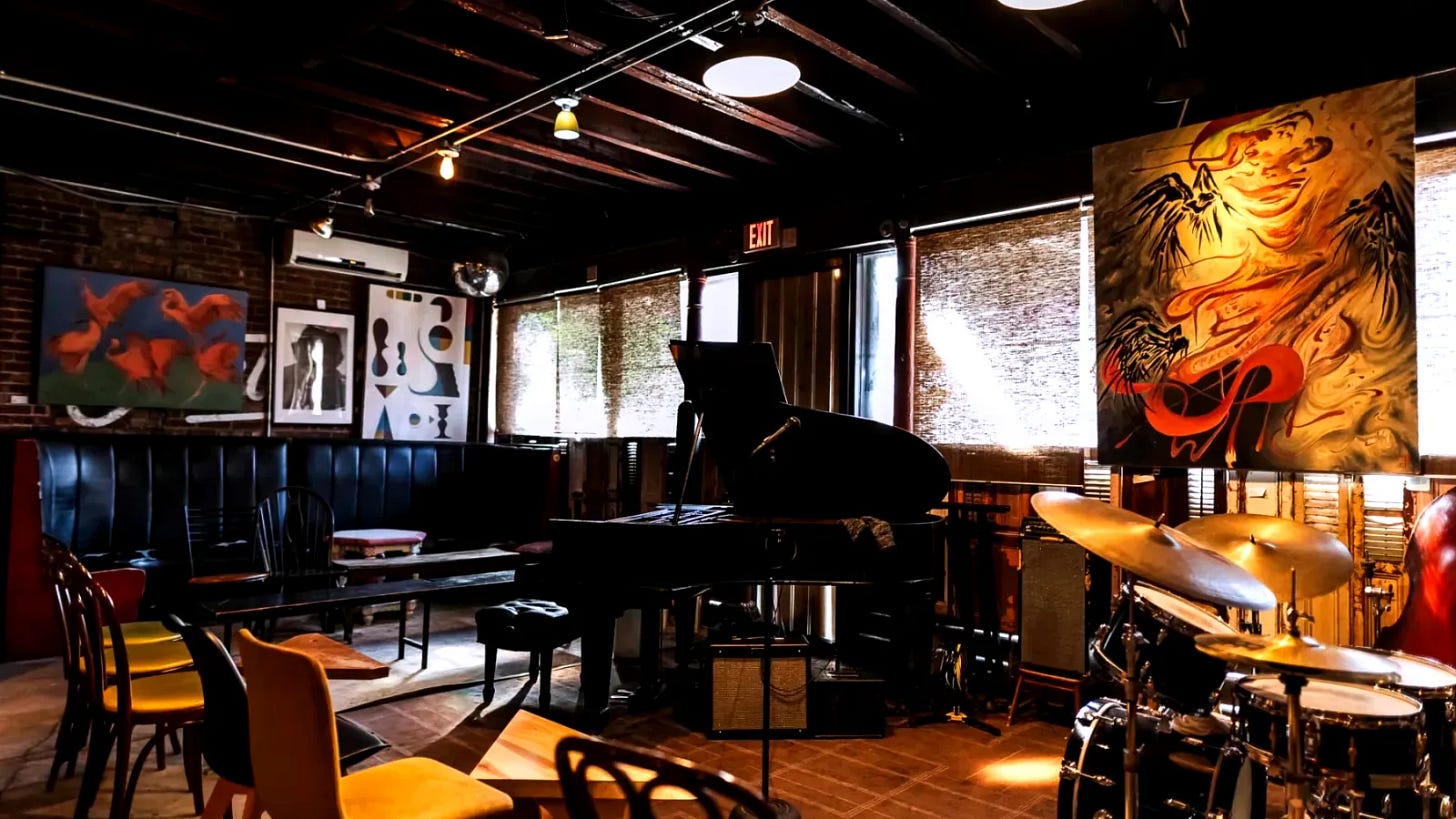 Bohemian interior of Ornithology Jazz Club in Bushwick Brooklyn, featuring mismatched furniture, Persian rugs, Bechstein grand piano, and intimate jazz performance space