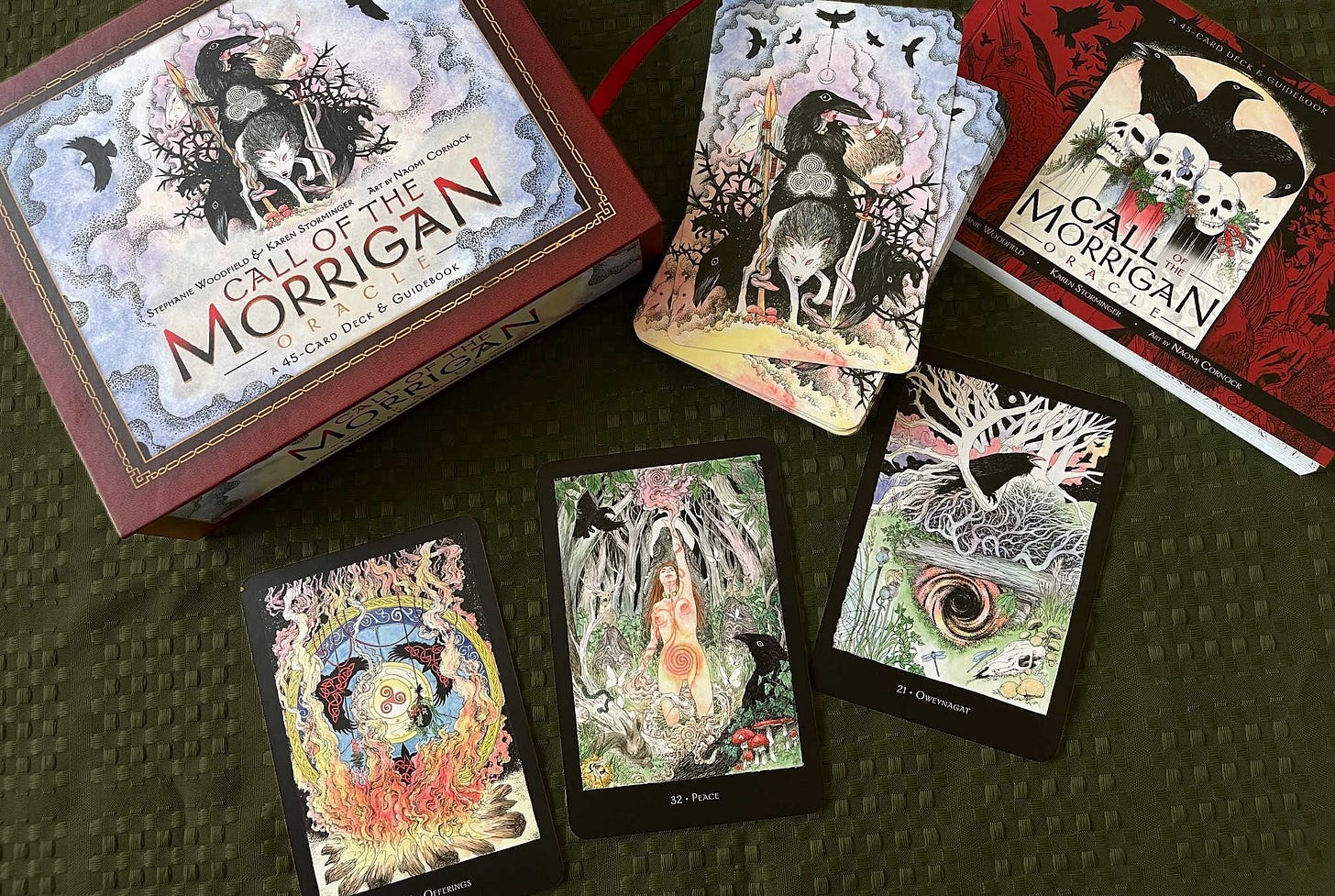 The Call of the Morrigan box, guidebook, deck and 3 cards from the deck are shown