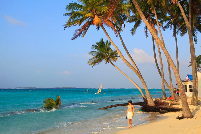 Woman walking on beach in the Maldives, Maafushi Island