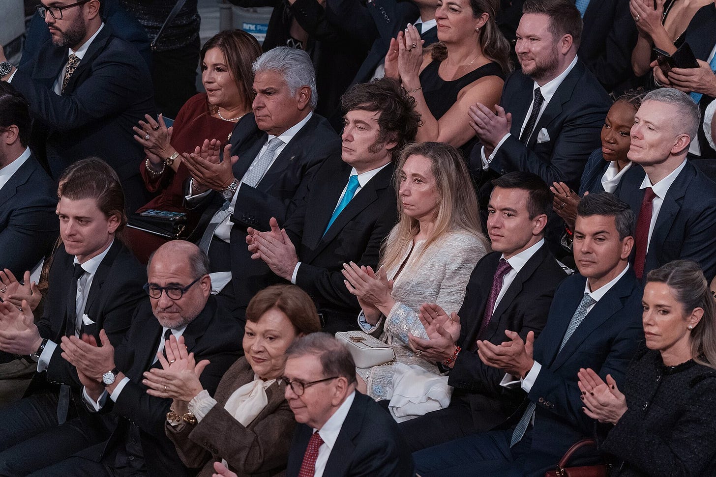 Rows of seated guests in formal dress applaud at a ceremony; among them, in the centre, Argentina's Javier Milei and Ecuador's Daniel Noboa. Rows of seated guests in formal dress applaud at a ceremony; among them, in the centre, Argentina's Javier Milei and Ecuador's Daniel Noboa.