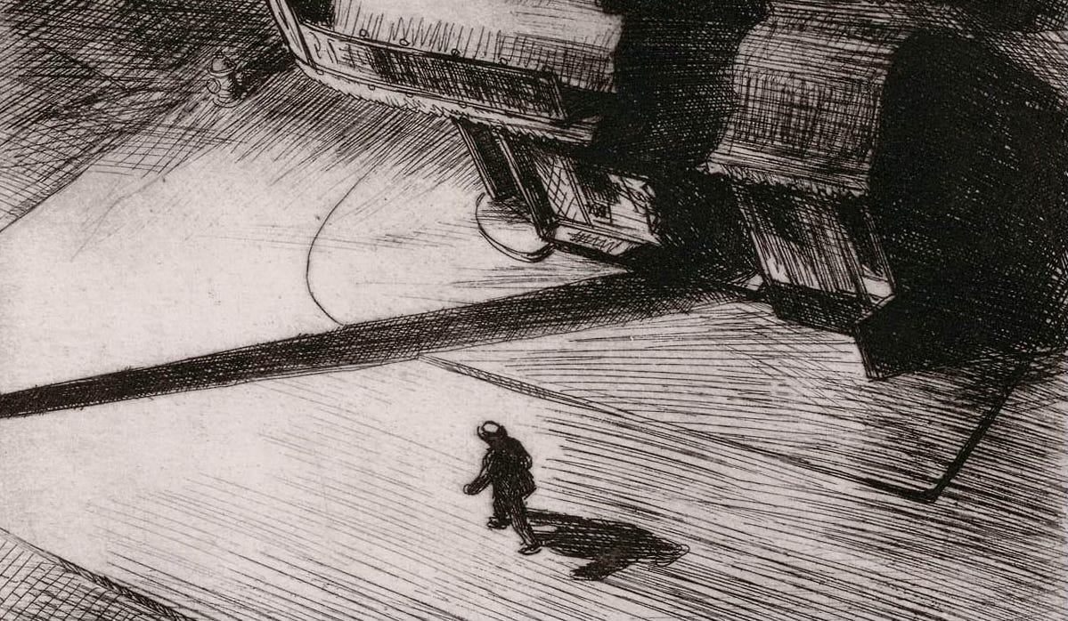 A man walking down a shadowy city street at night A man walking down a shadowy city street at night