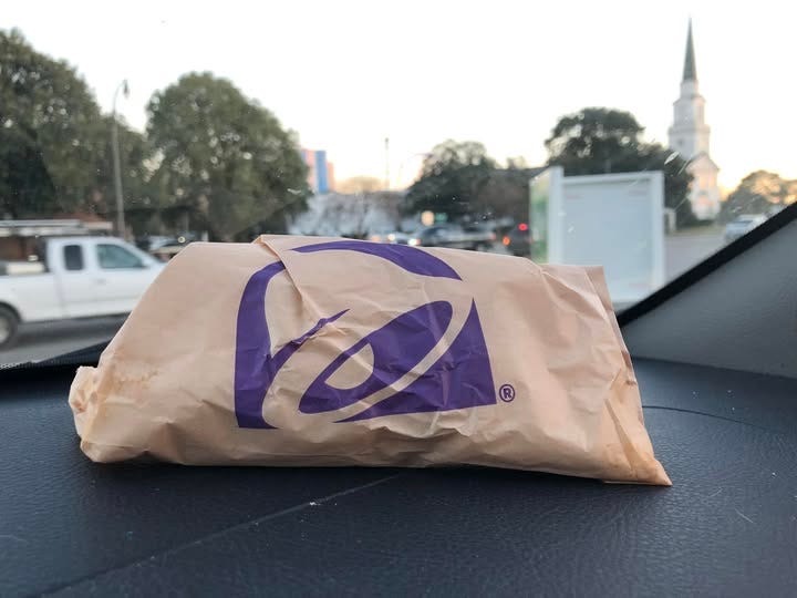 Taco bell taco on the dashboard of a car