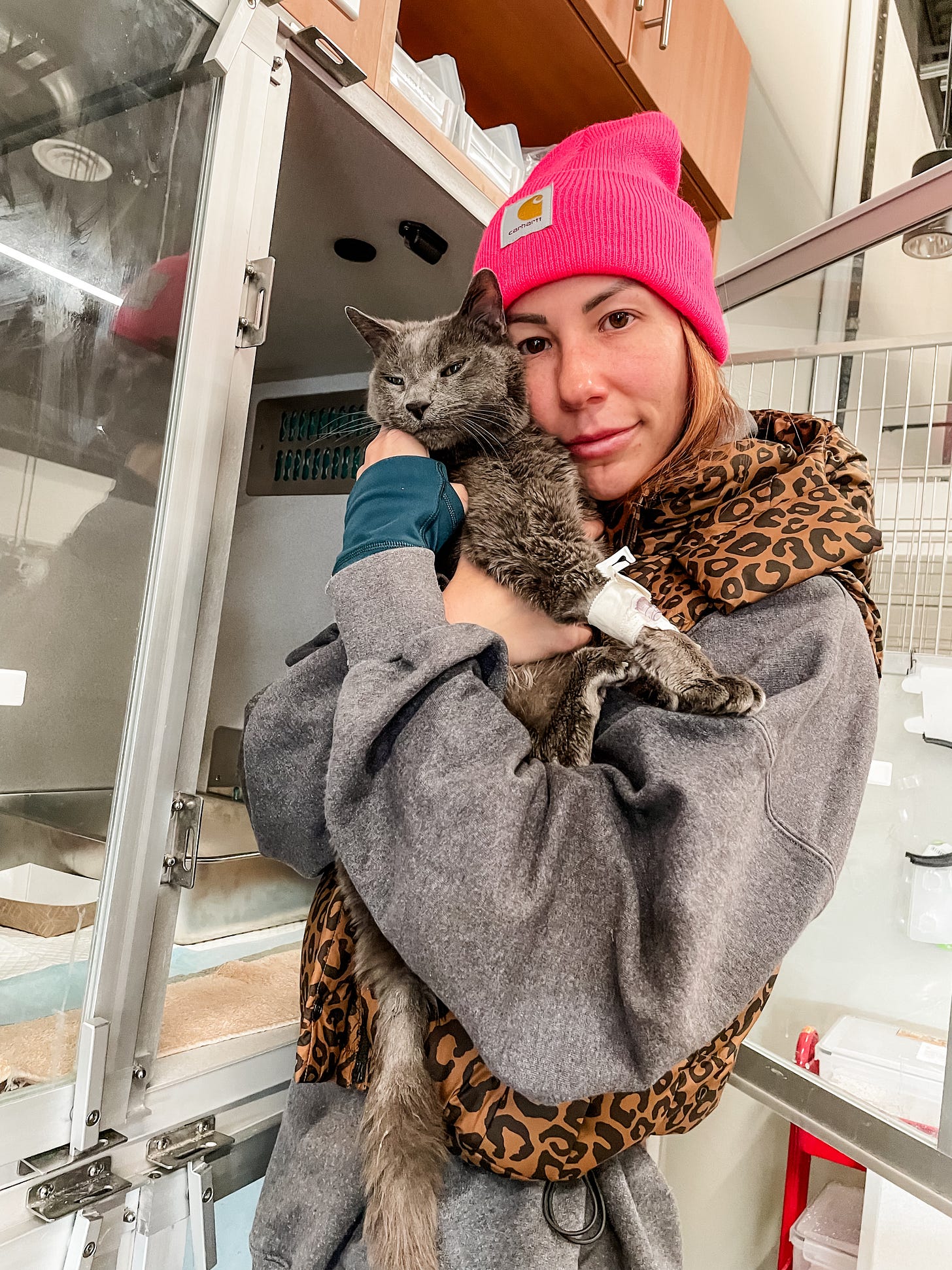 Emily holding her cat, Celine, in front of an oxygen tank at an emergency vet