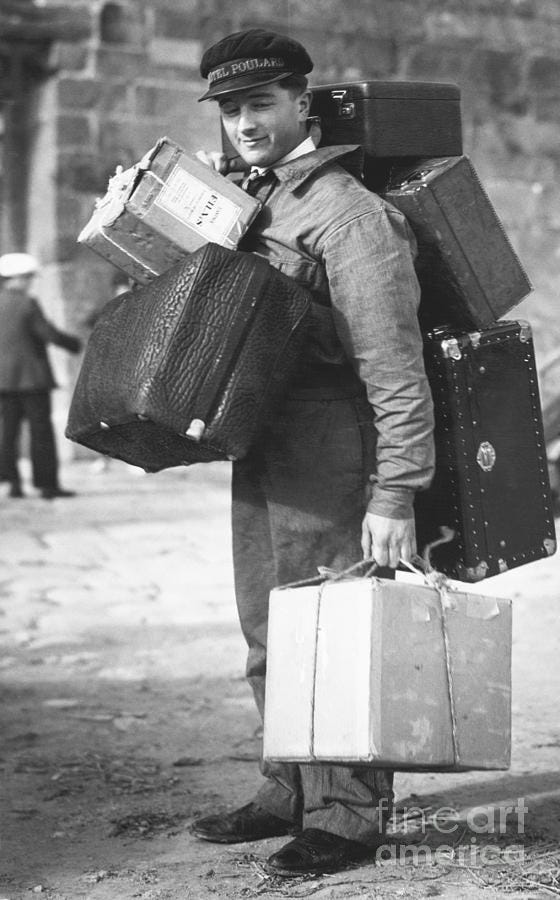 French Porter Carrying Heavy Luggage by Bettmann