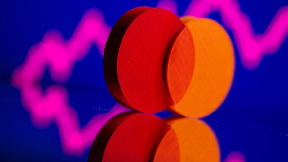 A 3D printed Mastercard logo is seen in front of displayed stock graph in this illustration taken September 20, 2021.