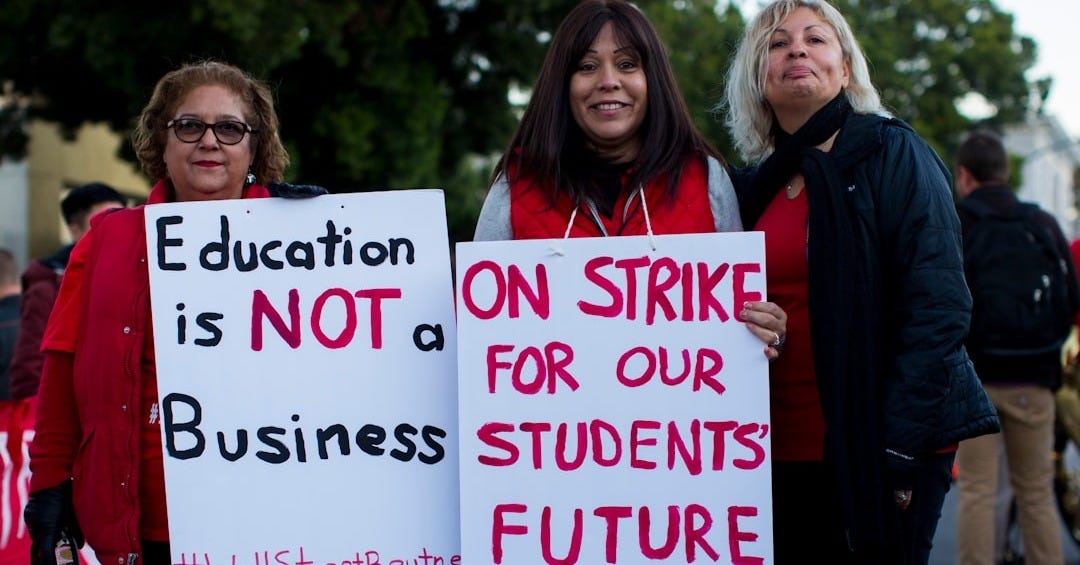 three women holding signges