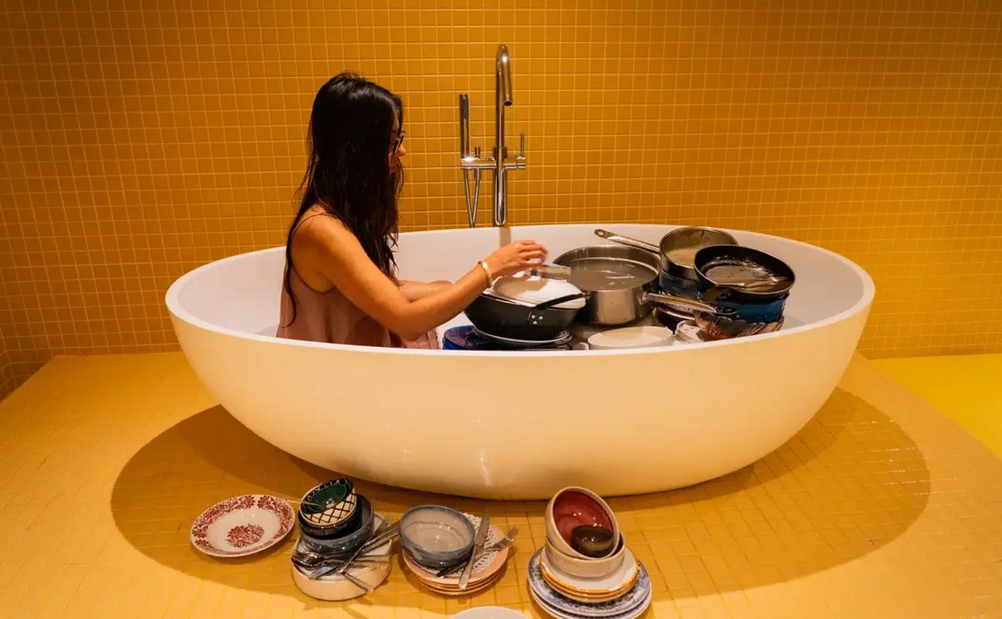 Visual and conceptual artist Nicole Vindel, a woman with long straight dark hair, performs "washing abundance" where she takes dirty dishes from the closing shift of a restaurant and washes them in the bath tub in a nearby hotel room during a severe drought in CataluƱa. The performance is a commentary on the finite supply of water and the political choices that govern its supply. Visual and conceptual artist Nicole Vindel, a woman with long straight dark hair, performs "washing abundance" where she takes dirty dishes from the closing shift of a restaurant and washes them in the bath tub in a nearby hotel room during a severe drought in CataluƱa. The performance is a commentary on the finite supply of water and the political choices that govern its supply.