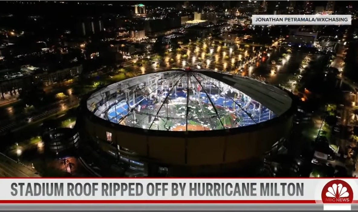Video screenshot, night view of the mostly-shredded roof of Tampa's Tropicana Field, with brightly-lit baseball field and stadium seats visible beyond the supporting beams of the domed roof Video screenshot, night view of the mostly-shredded roof of Tampa's Tropicana Field, with brightly-lit baseball field and stadium seats visible beyond the supporting beams of the domed roof