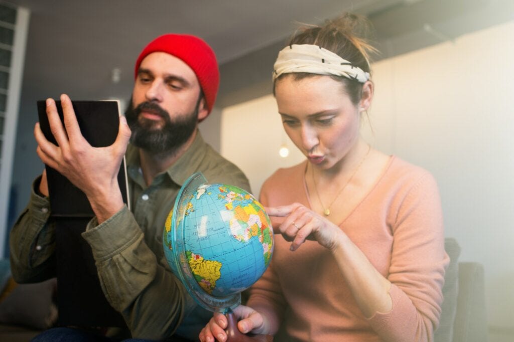 Happy young couple with globe choosing place for summer rest at leisure. Family travel concept. Happy young couple with globe choosing place for summer rest at leisure. Family travel concept.
