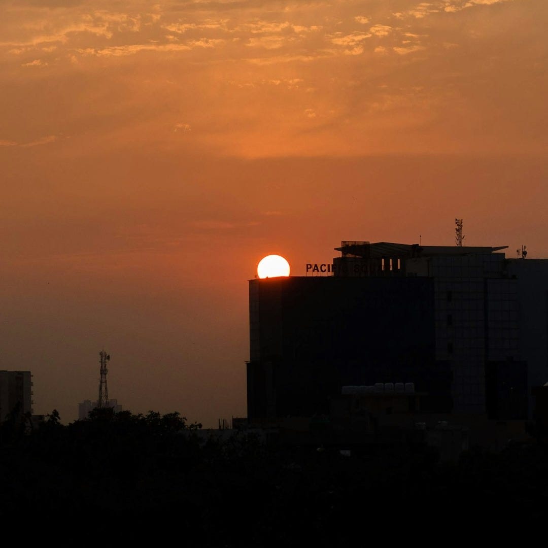 the sun is setting over a city skyline