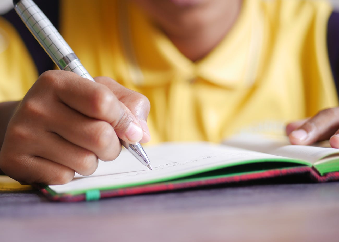 child writing with a pen