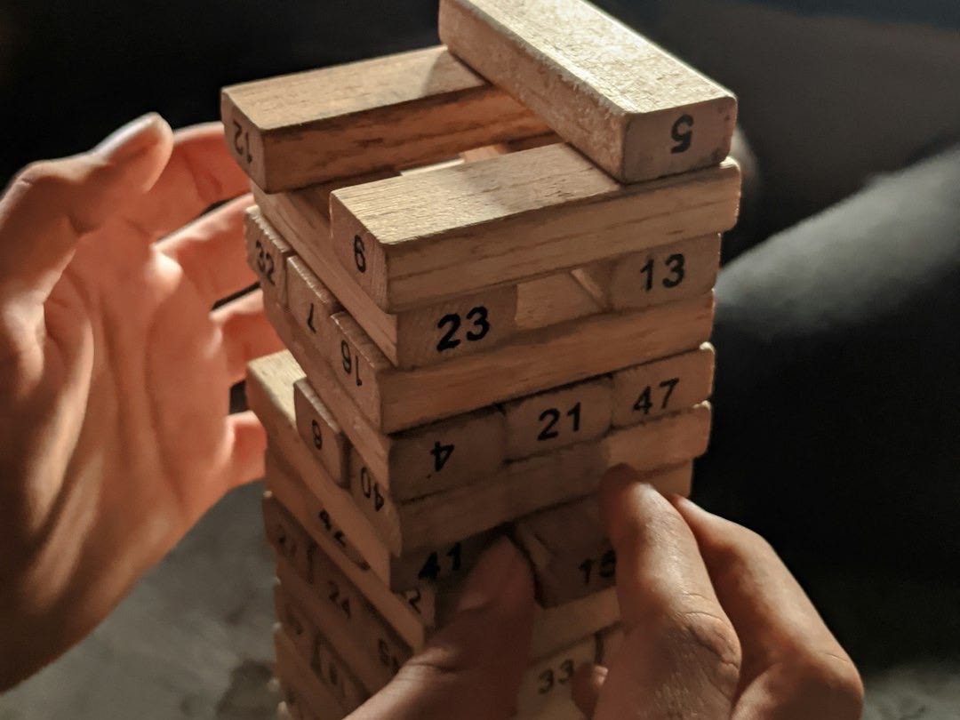a person holding a stack of wooden blocks
