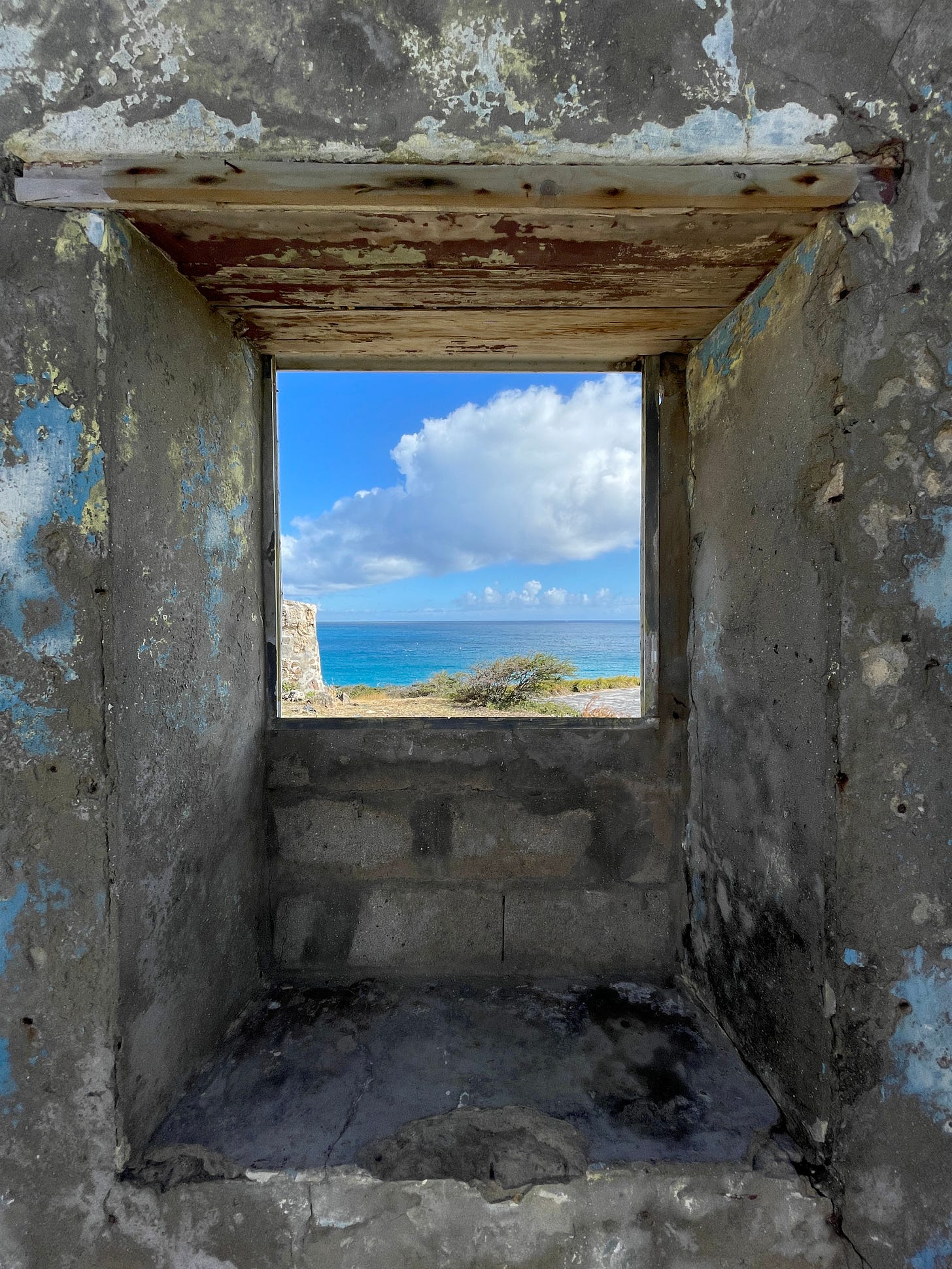 A view of the sea through a window of a structure at Fort Amsterdam.