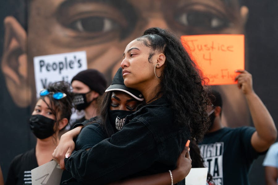 Two women embrace in front of a mural of George Floyd following the guilty verdict the trial of Derek Chauvin, a white former Minneapolis police officer, was convicted of murdering George Floyd.