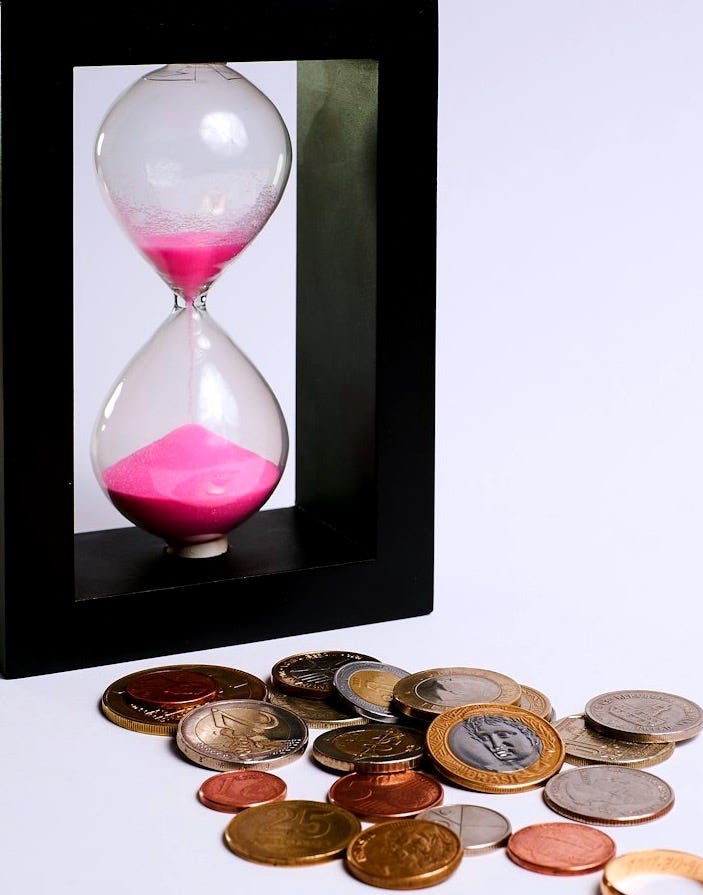 clear hour glass with coins
