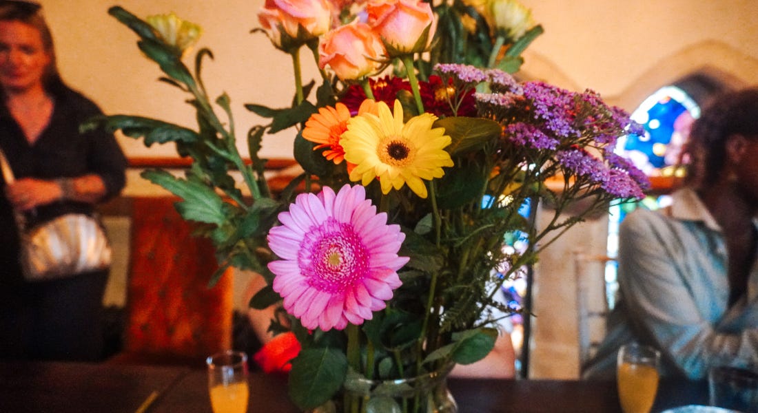 A bouquet of flowers with pink, yellow, and orange flowers in it A bouquet of flowers with pink, yellow, and orange flowers in it