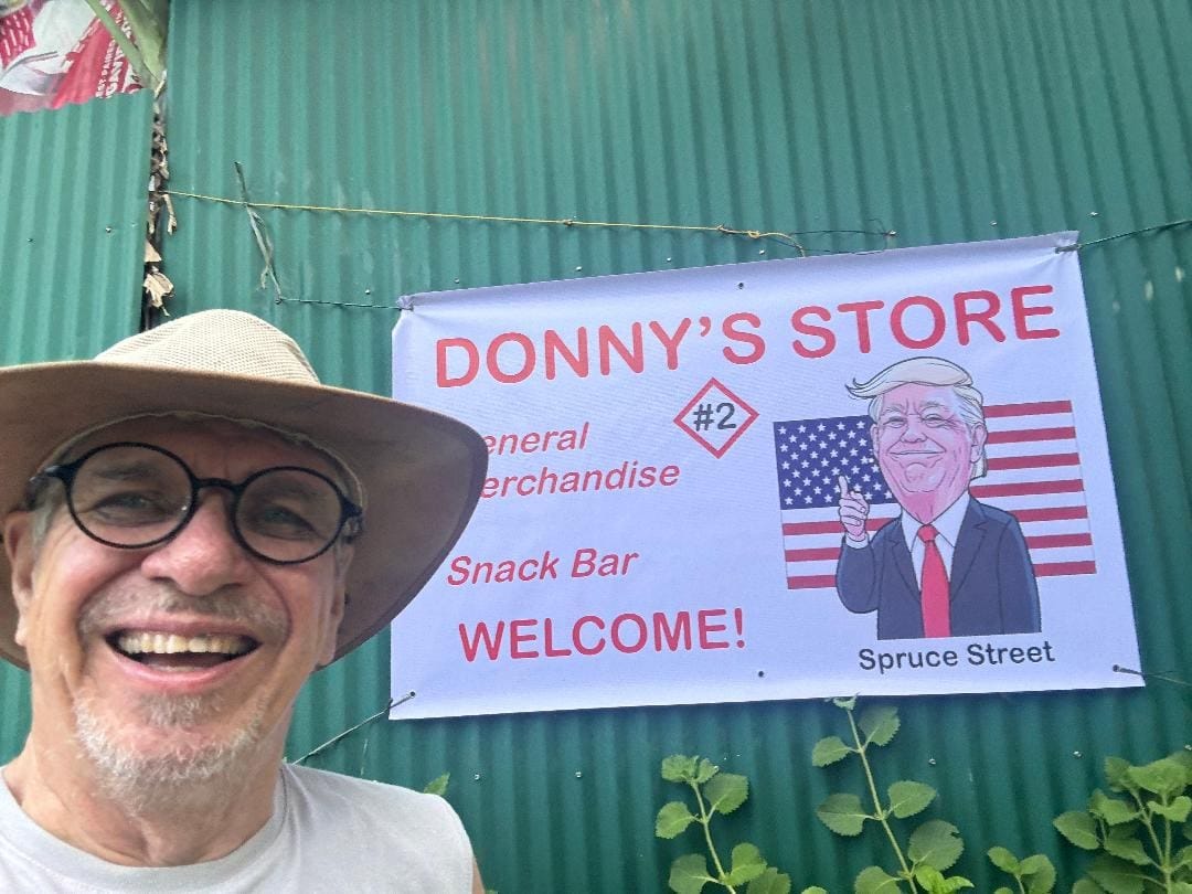 Man smiling in front of Donny's Store sign.