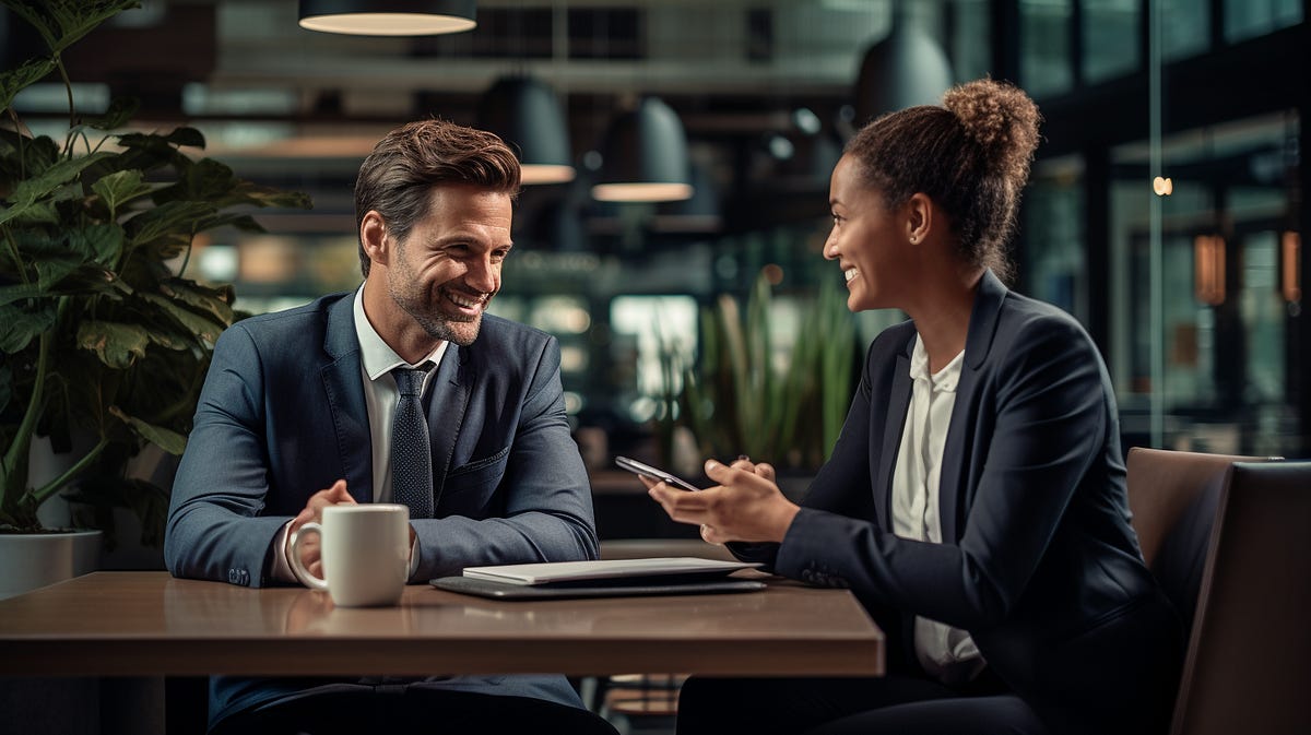 a man and a woman reviewing a presentation while sitting together at a table a man and a woman reviewing a presentation while sitting together at a table