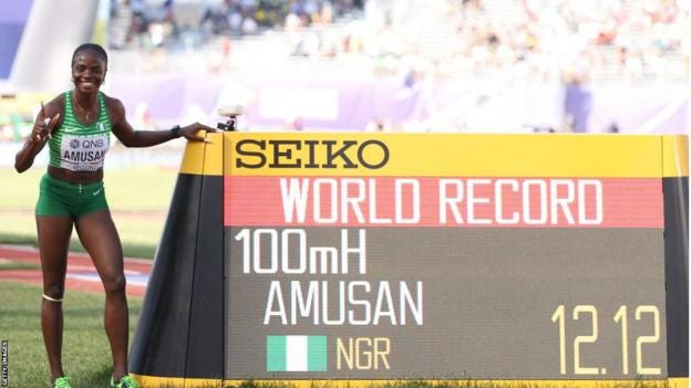 Tobi Amusan stands next to a screen with confirmation of her world record time for 100m hurdles Tobi Amusan stands next to a screen with confirmation of her world record time for 100m hurdles