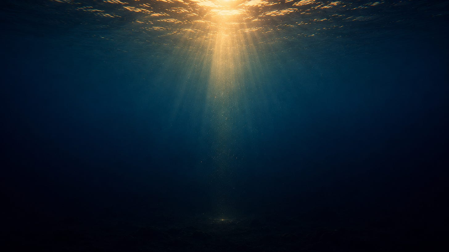 A wide underwater scene with golden sunlight entering from the ocean surface and fading into deep blue darkness, leaving only a faint trace of light near the barely visible seabed. A wide underwater scene with golden sunlight entering from the ocean surface and fading into deep blue darkness, leaving only a faint trace of light near the barely visible seabed.