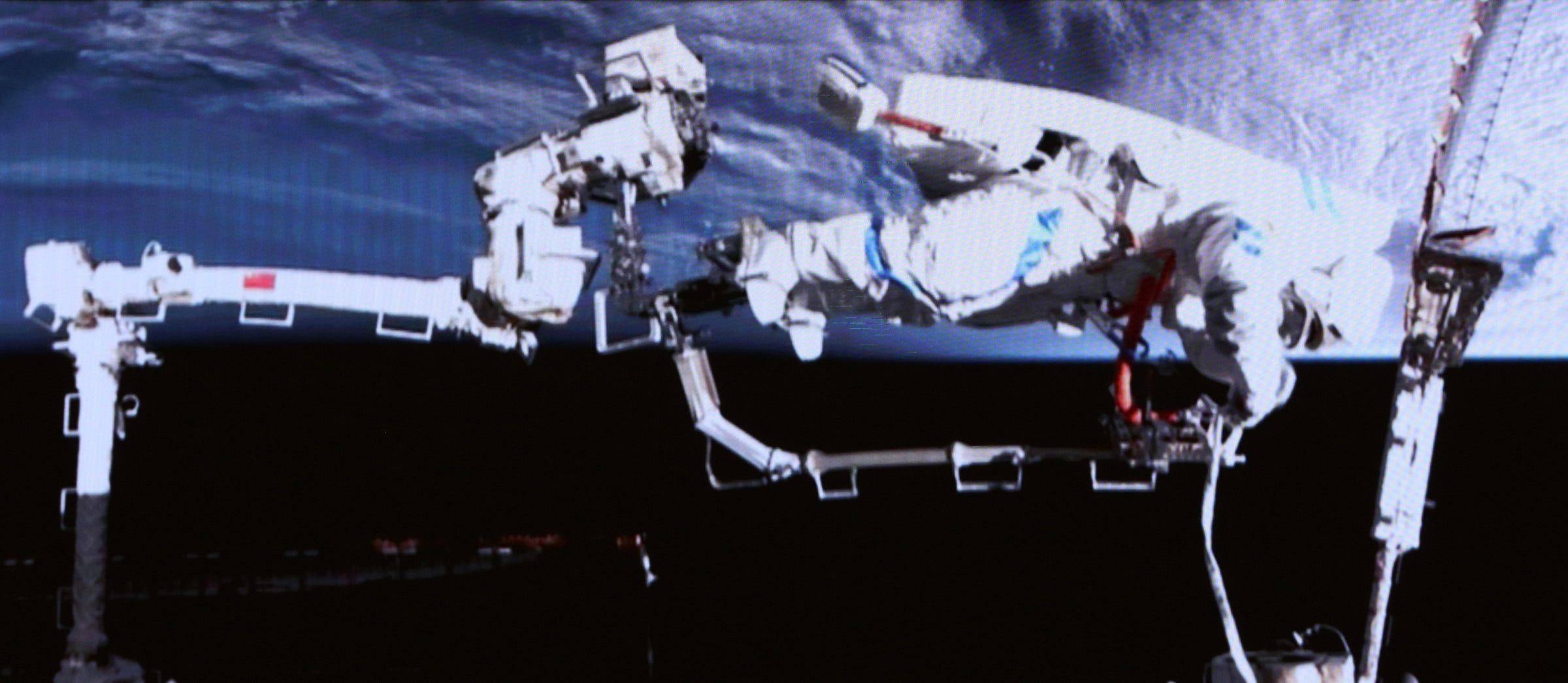 Wu Fei on the end of the Tiangong Space Station’s robotic arm inspecting the attachment point of a solar panel on March 16th 2026.