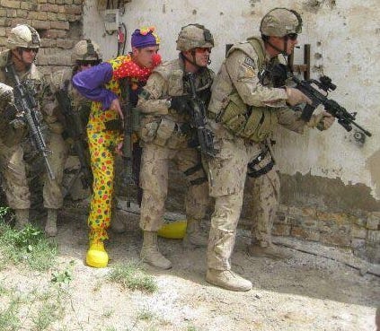A group of armed soldiers with a clown in their ranks A group of armed soldiers with a clown in their ranks