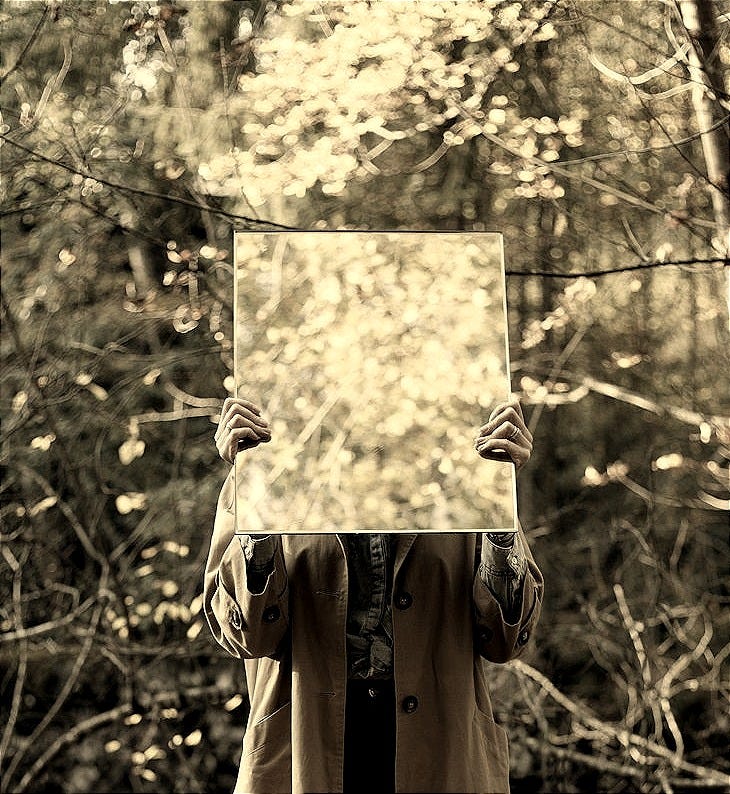 woman in brown coat holding floral frame