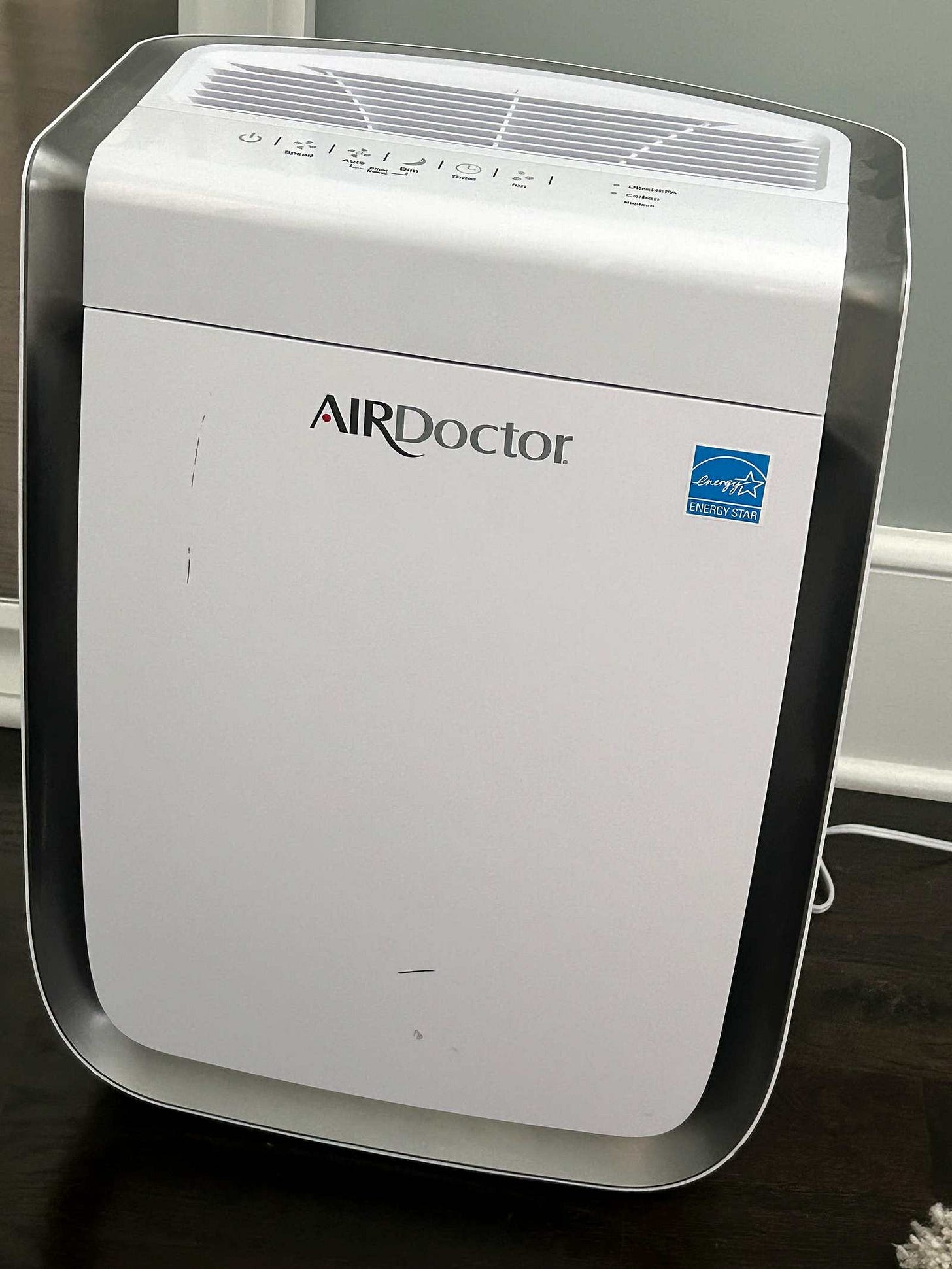 A white AirDoctor air purifier on a wood floor A white AirDoctor air purifier on a wood floor
