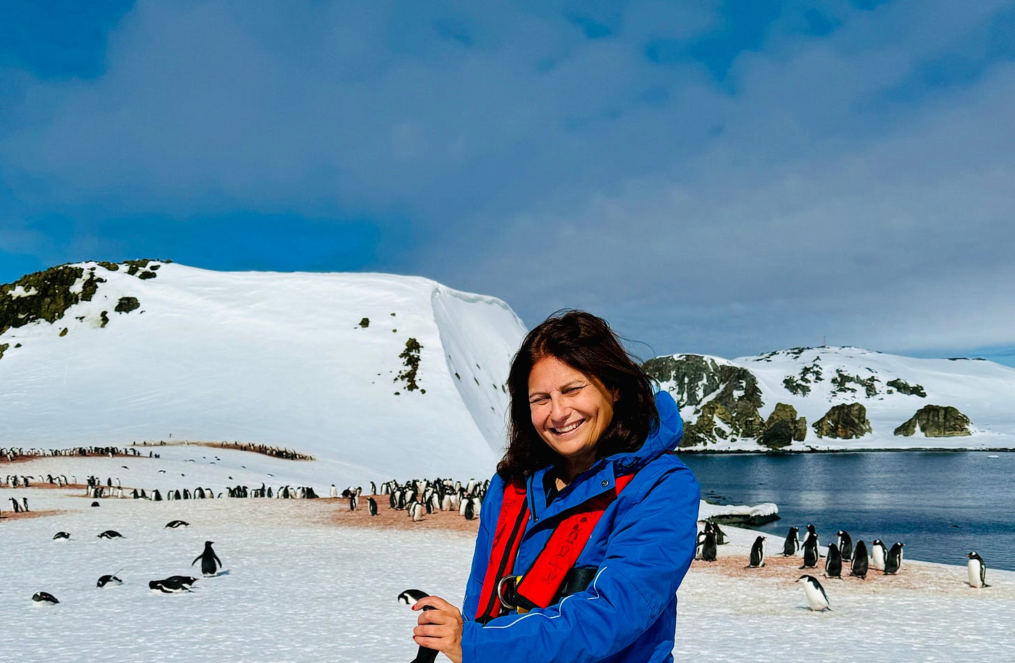 Mujer con pinguinos en la Antártida