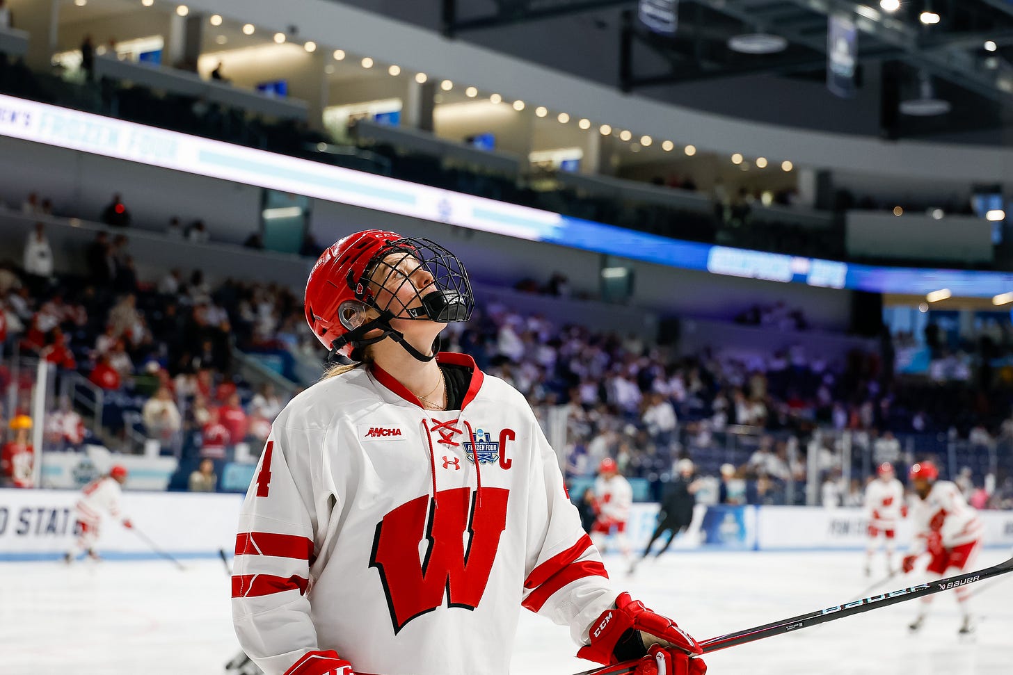 Caroline Harvey looks up during on-ice warmups with a few players in the background Caroline Harvey looks up during on-ice warmups with a few players in the background