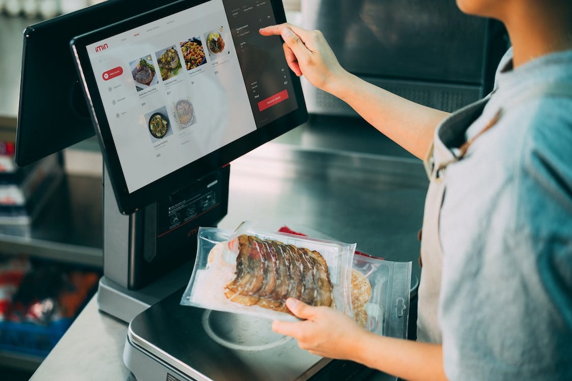 Free Person Standing in Front of a Monitor Holding a Pack of Food and  Stock Photo