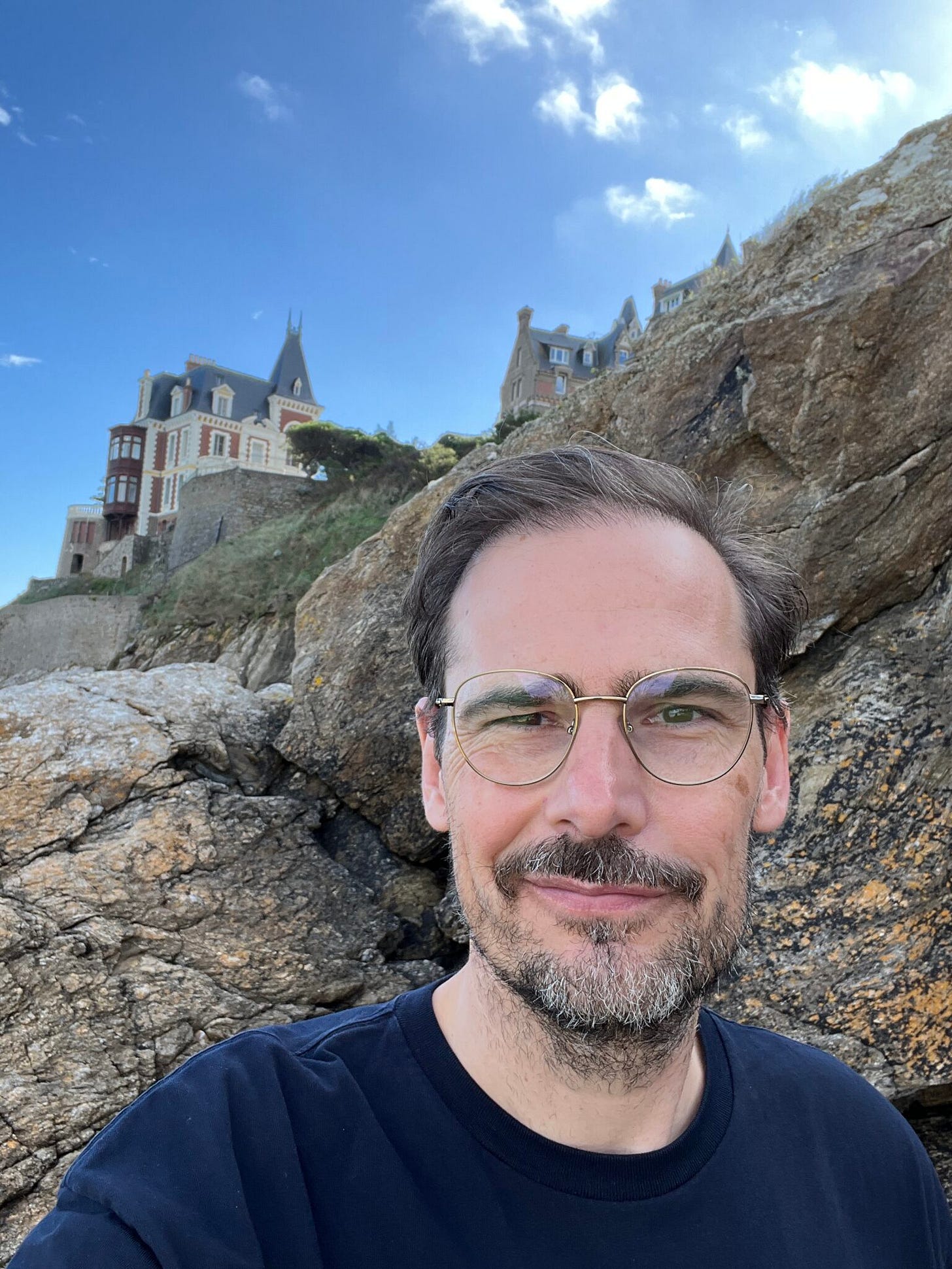 Jochen in Dinard vor Villa, die oben auf Steinklipen thront, Frankreich 