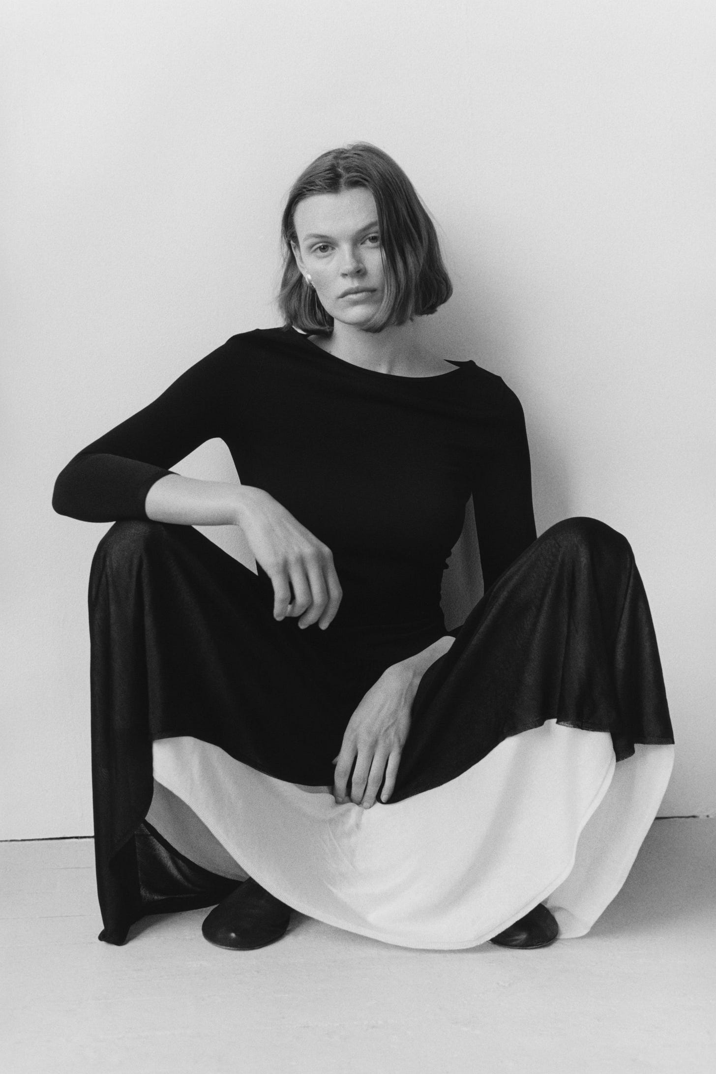 Image may contain Face Head Person Photography Portrait Adult Sitting Happy Smile Body Part Finger and Hand