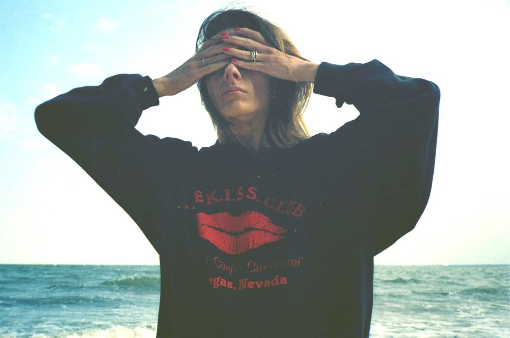 woman covering eyes by sea woman covering eyes by sea
