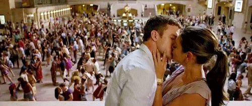 Still from Friends with Benefits, showing Justin Timberlake and Mila Kunis kissing in front of a backdrop of a giant dancing flash mob in Grand Central Station