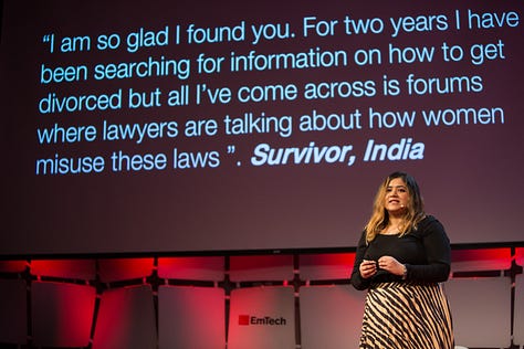 In the first image, Hera is standing on a stage in front of a big screen that is showing a quote from a survivor of gender-based violence. The second image is a close-up portrait of Hera. She's standing in front of a brick wall, her hair loose, wearing red lipstick and a plain black top. In the third image, Hera is standing on a TED conference stage speaking.