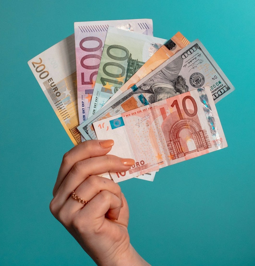 person holding fan of 100 us dollar bill