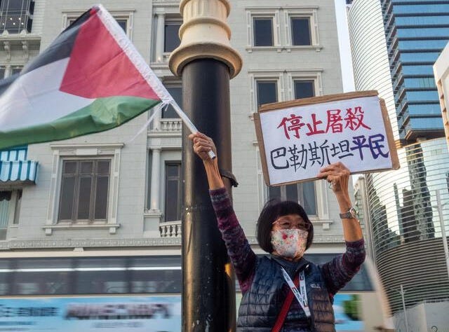 An activist holds a flag of Palestine along with a placard during the protest demanding the United States, the Zionist movement, and the United Kingdom stop the genocide on Salisbury Road. An activist holds a flag of Palestine along with a placard during the protest demanding the United States, the Zionist movement, and the United Kingdom stop the genocide on Salisbury Road.