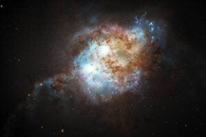 This artist's concept shows the brilliant glare of two quasars residing in the cores of two galaxies that are in the chaotic process of merging. The gravitational tug-of-war between the two galaxies ignites a firestorm of star birth.