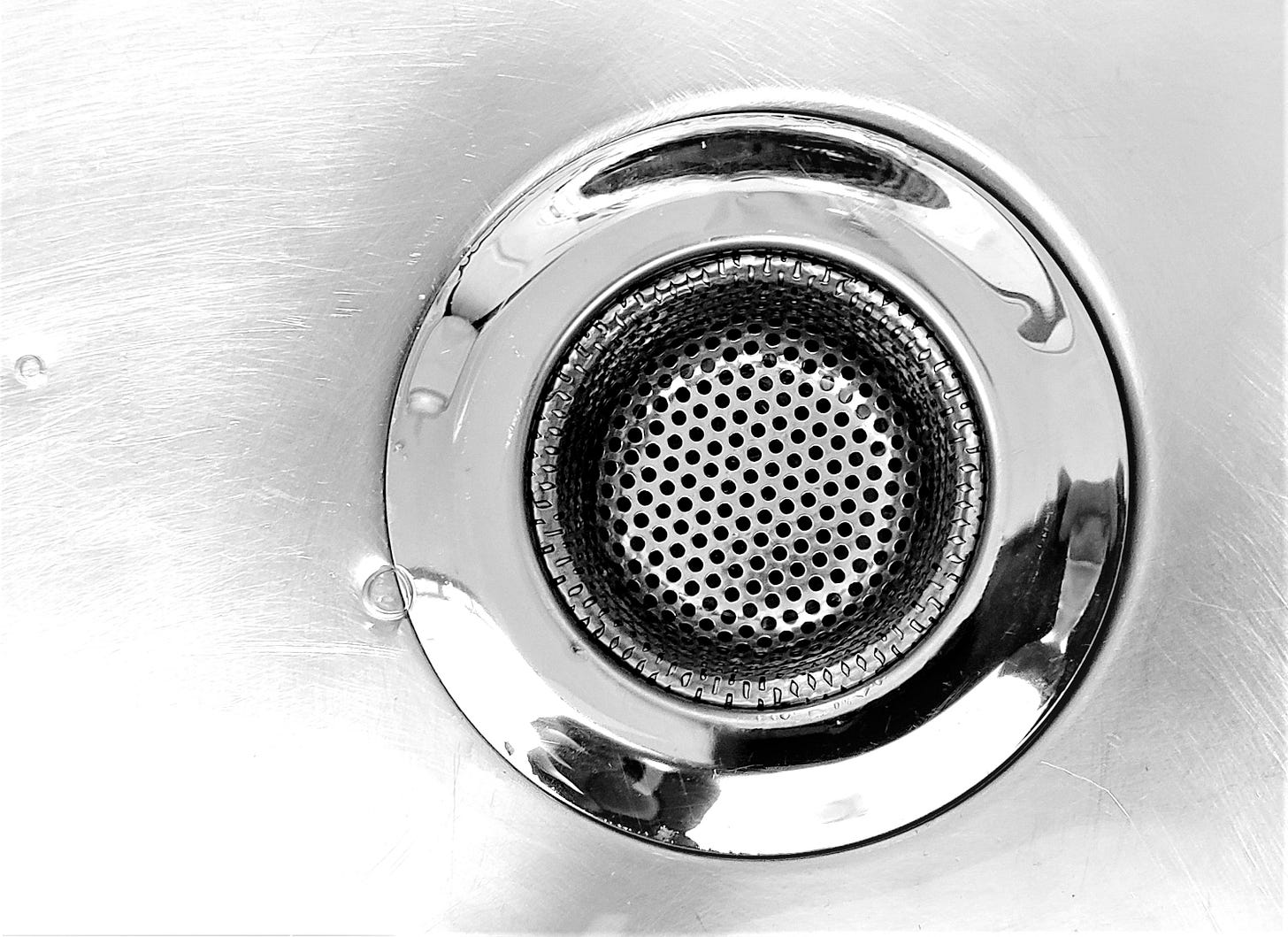 a close up of a metal sink drain a close up of a metal sink drain