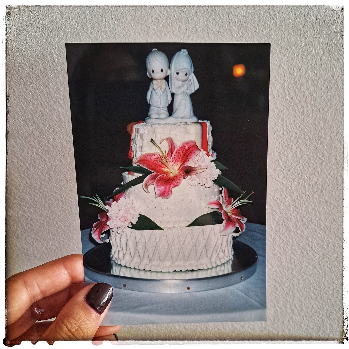 Tarta de novios de tres pisos adornada con flores y en la parte superior figura de novio y novia. Foto de archivo familiar. Tarta de novios de tres pisos adornada con flores y en la parte superior figura de novio y novia. Foto de archivo familiar.