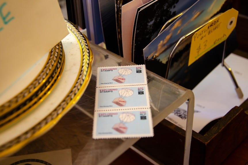 Three stamps are displayed for sale on a table. Three stamps are displayed for sale on a table.