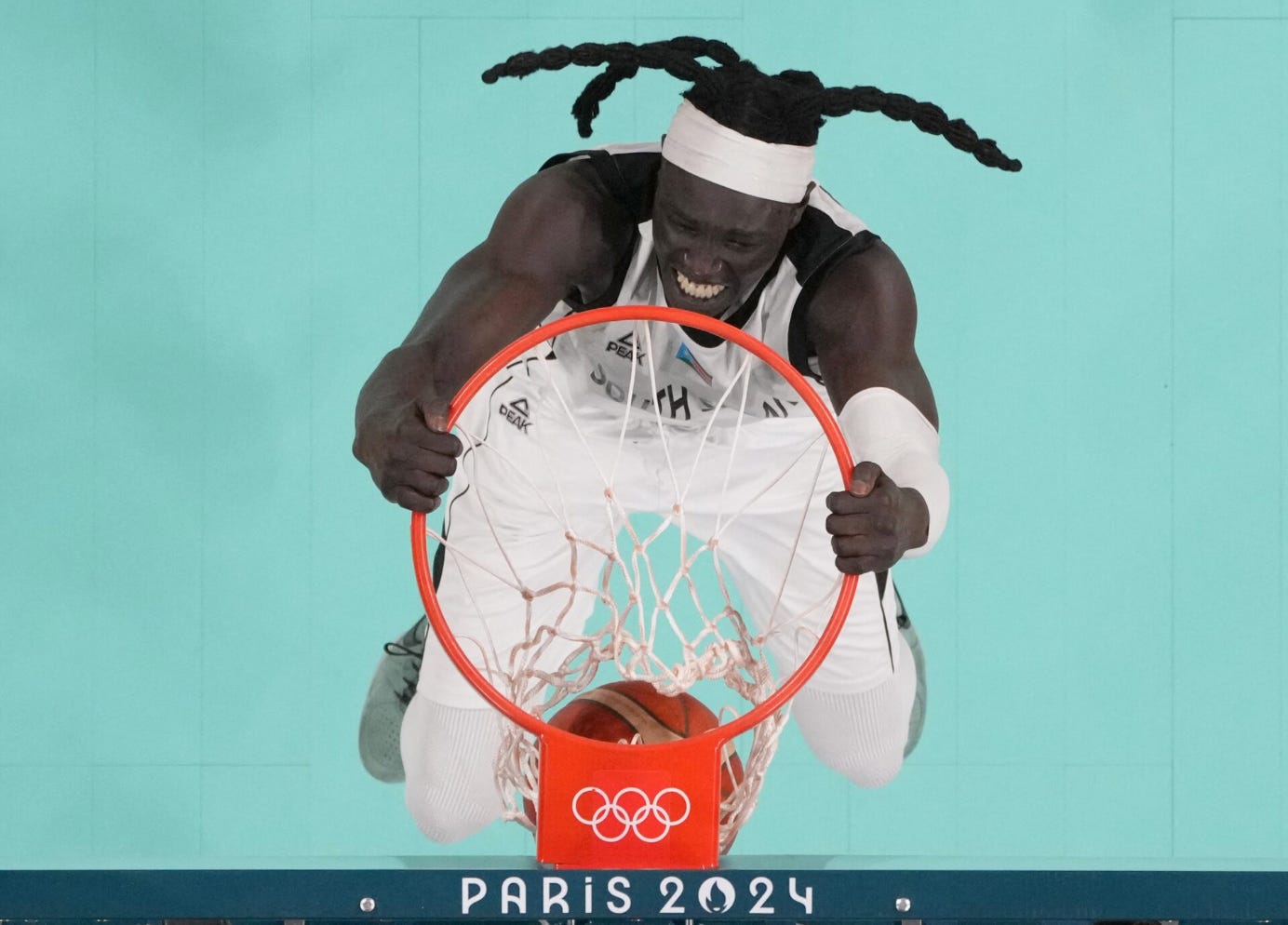 A person jumping into a basketball hoop

Description automatically generated