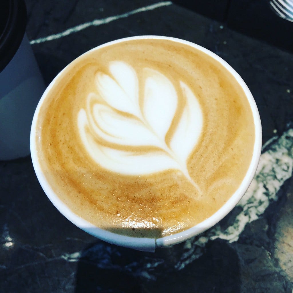 Coffee cup with a leaf pattern in the foam. "Coffee" by brendonjford is licensed under CC BY-NC 2.0. 