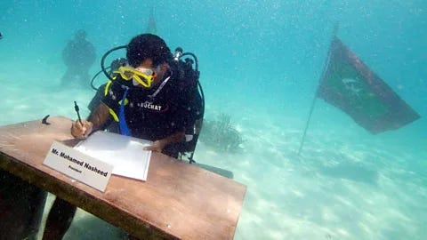 Alamy The former president of the Maldives signs a document in scuba gear, underwater (Credit: Alamy)