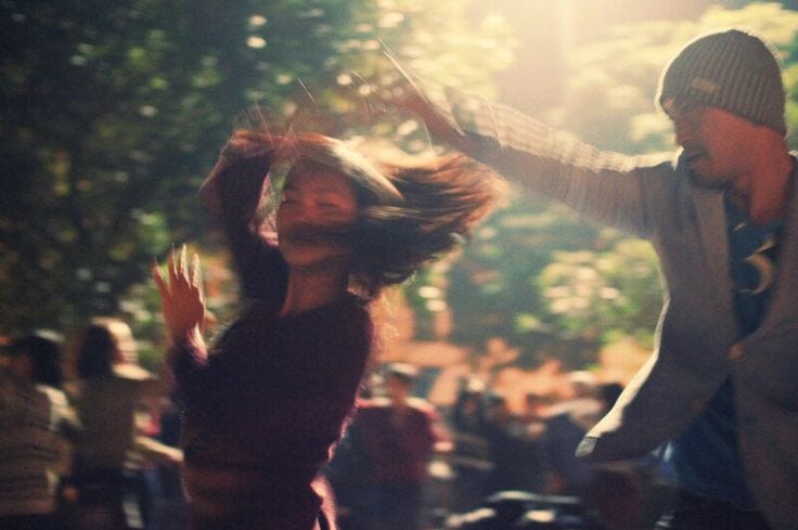 This may contain: a man and woman dancing in the street This may contain: a man and woman dancing in the street