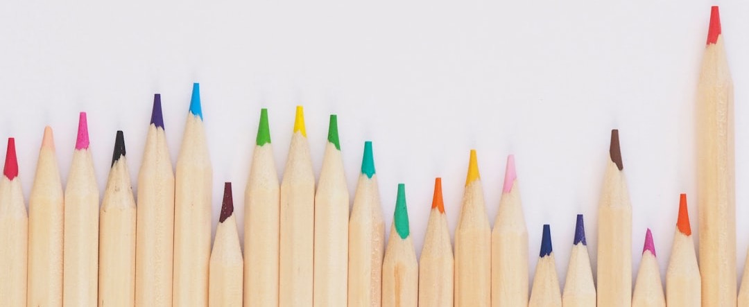 colored pencil lined up on top of white surface