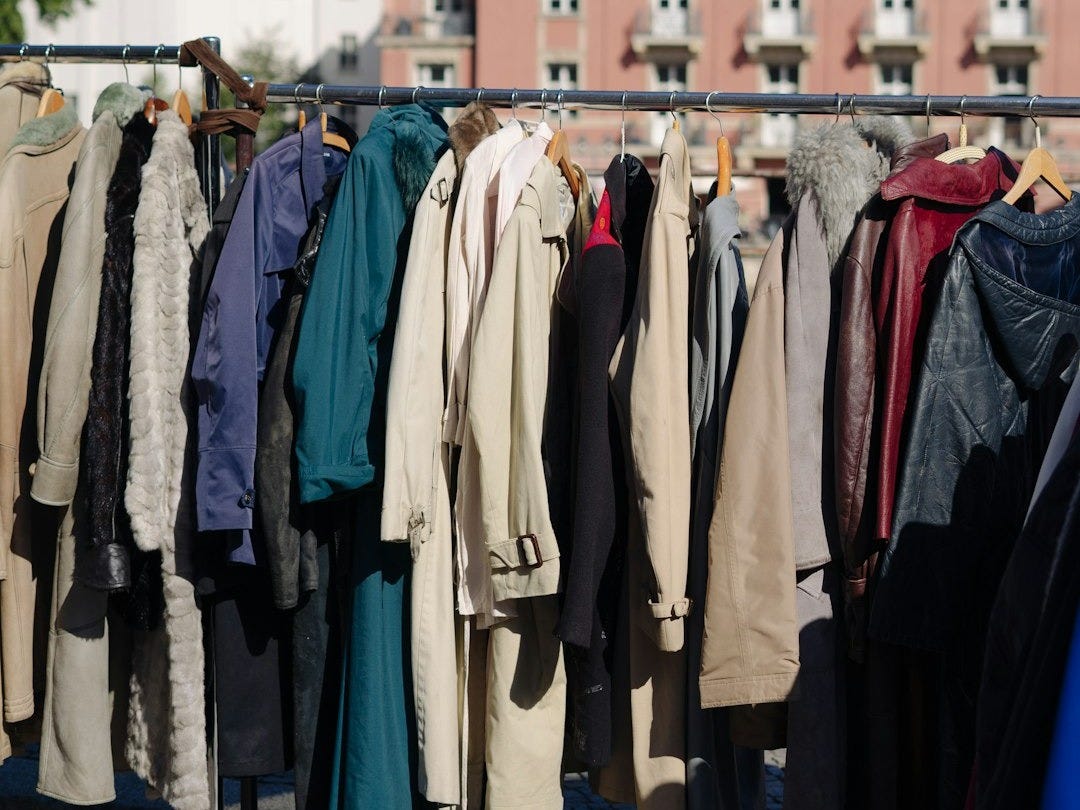 a rack of coats and jackets in front of a building a rack of coats and jackets in front of a building