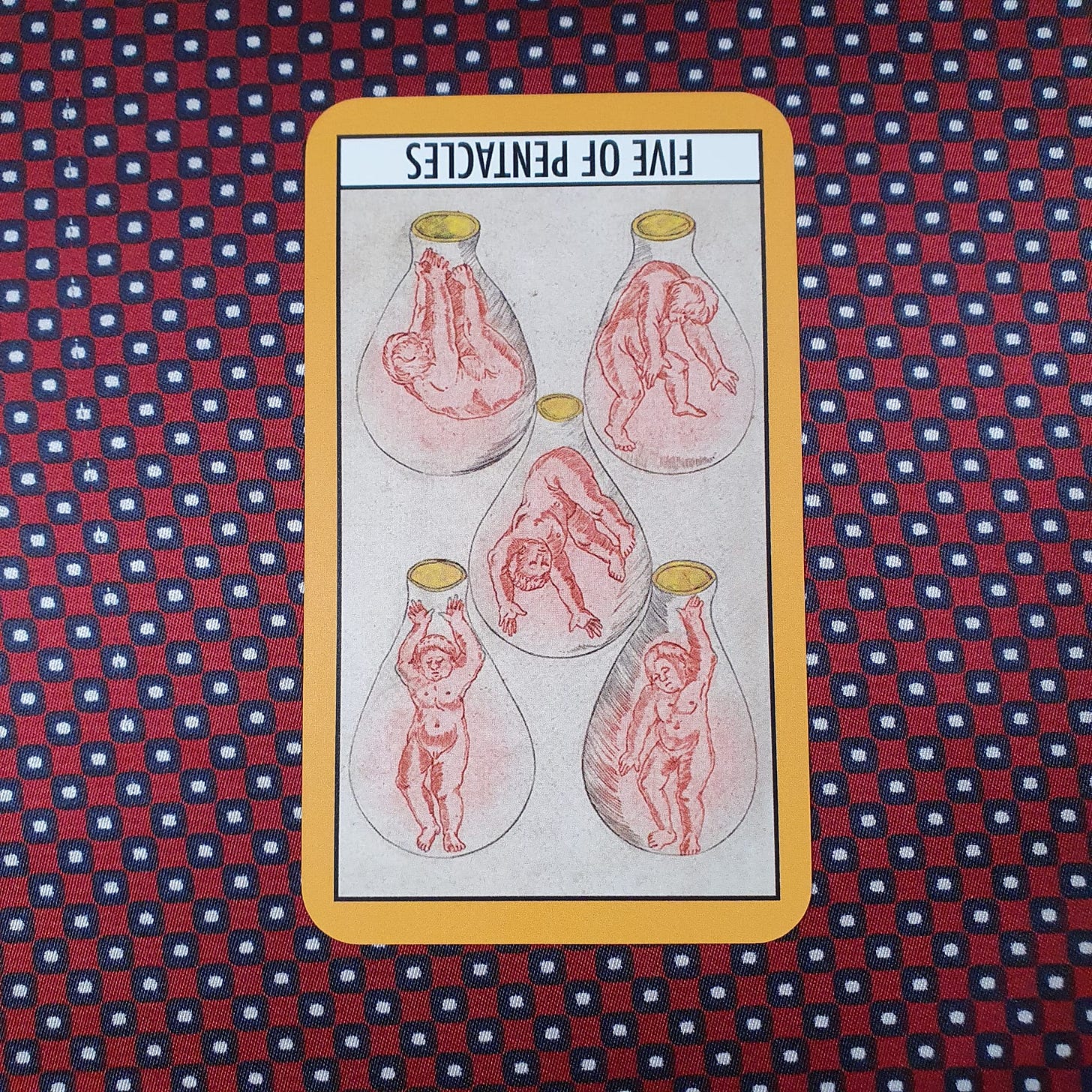 Five of Pentacles tarot card shown reversed depicting figures enclosed in glass vessels - symbolic imagery connected to recovery, vulnerability and creative confidence. Five of Pentacles tarot card shown reversed depicting figures enclosed in glass vessels - symbolic imagery connected to recovery, vulnerability and creative confidence.